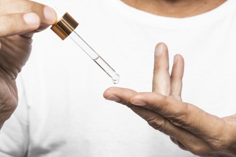close-up-hands-holding-serum-pipette (1)